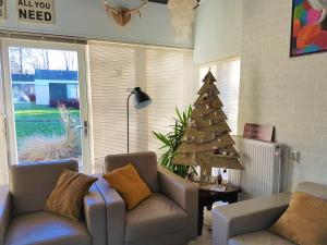 a living room with a christmas tree and a couch at Vakantiehuis Elisa Zuid Limburg in Simpelveld