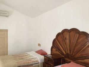 een slaapkamer met een groot houten bed en een dressoir bij Nichos Beach Villas in Playa Azul