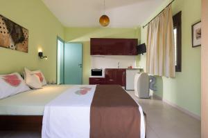 a bedroom with a large bed and a kitchen at Niriides in Porto Koufo