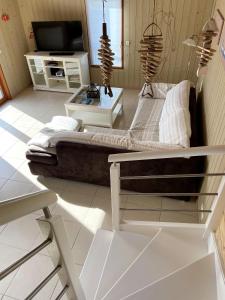 un salon avec un canapé et une télévision dans l'établissement La Moussette, à Jullouville