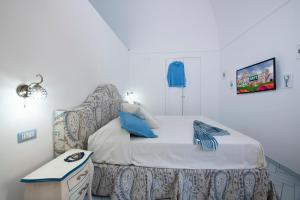 a small bedroom with a bed with a chair at Maison Don Rafe' in Positano