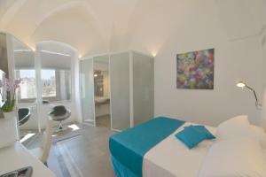 a bedroom with a bed and a desk with a chair at Sunshine Luxury Rooms in Ostuni
