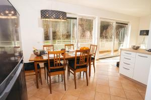 cocina y comedor con mesa y sillas en Aparthotel Rosa 404 en Podčetrtek
