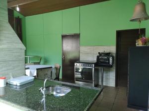 a kitchen with a sink and a stove at Casa para hospedagem temporário in Joinville