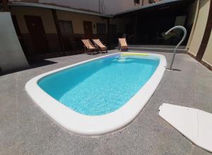 a swimming pool with two chairs and a bath tub at Pousada Pelourinho in Mucuri +22 photos