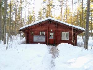 una pequeña cabaña de madera en el bosque en la nieve en Holiday Cabin Kerimaa 102 en Savonlinna