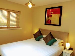 a bedroom with a white bed with two pillows at Valley Mount House & Apartment in Harrogate