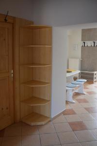 a room with wooden shelves in a room with toilets at Alexandra Apartman Sárvár in Sárvár