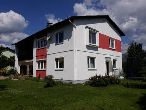 a white and red house on a green field at Ferienwohnung Palme in Trofaiach