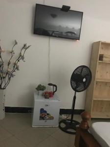een kamer met een ventilator aan de muur en een plank bij BBQ Lounge in Dar es Salaam