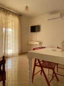 a living room with a white table and a chair at 88 Apartment Himare in Himare