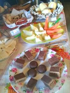 two plates of food on a table with desserts at Pousada Cantinho das Fadas in Conceição da Ibitipoca