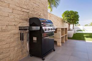 una barbacoa junto a una pared de ladrillo en Villa La Caleta Golf en Adeje