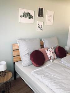 a bed with white sheets and red pillows on it at Schwarzburg Appartments in Sondershausen