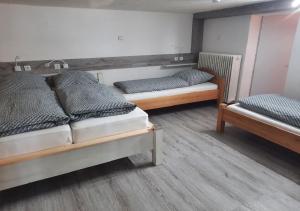 2 Betten in einem Zimmer mit Holzböden in der Unterkunft Exklusive Naturoase direkt am Ars Natura Wanderweg mit Panoramablick auf Melsungen in Melsungen