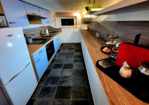 a kitchen with white cabinets and a black tile floor at Exklusive Naturoase direkt am Ars Natura Wanderweg mit Panoramablick auf Melsungen in Melsungen