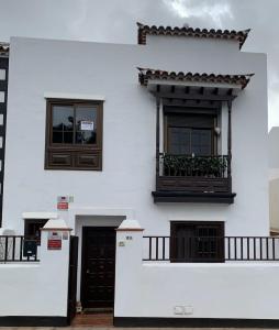 a white building with two windows and a balcony at guajara-loft in Las Lagunas