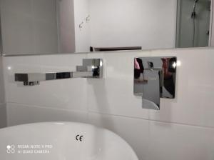 y baño con lavabo blanco y espejo. en La Casa di Miriam, en Petralia Sottana
