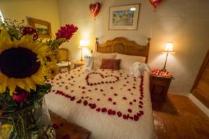 een slaapkamer met een bed met een opgemaakt hart bij Villa Mirasol in San Miguel de Allende