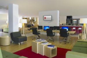 an office with chairs and a table and a desk with computers at Fiesta Inn Leon in León