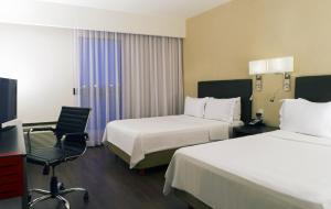 Postel nebo postele na pokoji v ubytování Fiesta Inn Leon