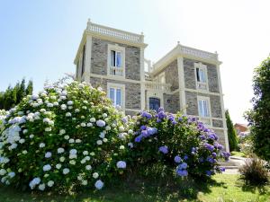 a large stone building with flowers in front of it at Villa Auristela in Navia