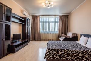 チュメニにあるApart Hotel Abajourのベッド1台、薄型テレビが備わるホテルルームです。