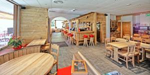 an empty restaurant with wooden tables and chairs at Chez Chantal in Siviez