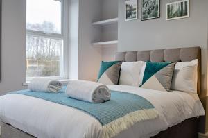 um quarto com uma cama com toalhas em Copper House em Swansea
