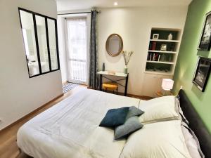 a bedroom with a large white bed and a window at Premier Chapitre - Design et charme de l'ancien en cœur de ville in Saint-Brieuc