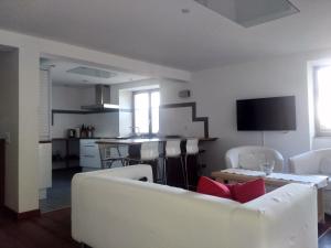 a living room with two white couches and a kitchen at Appartement "Luigi Loft" in Intragna