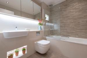 ein Badezimmer mit einem WC, einem Waschbecken und einer Badewanne in der Unterkunft City Living apartments in London