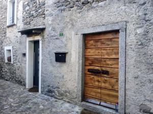 a large wooden door on a stone building at Guesthouse "Castello del Nucleo" in Intragna