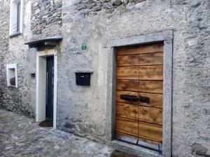 a large wooden door on a stone building at Guesthouse "Castello del Nucleo" in Intragna