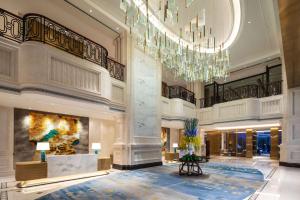 a lobby of a hotel with a chandelier at Ramada Plaza by Wyndham Wuhan Huangpi in Wuhan