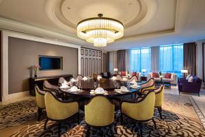 a dining room with a table and chairs and a chandelier at Ramada Plaza by Wyndham Wuhan Huangpi in Wuhan