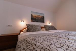 a bedroom with a large bed with two pillows at Apartments & Rooms Malej in Bohinj