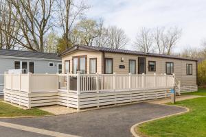 a mobile home with a white fence at Cottontail Lodge - Hot tub - Pet Friendly in South Cerney
