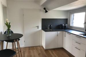 a kitchen with white cabinets and a table and a window at Apartment Frankfurt, top renoviert, 65qm DG in Bergisch Gladbach