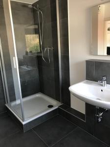 y baño con ducha y lavamanos. en Apartment Frankfurt, top renoviert, 65qm DG, en Bergisch Gladbach