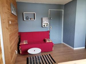 レ・デュー・アルプにあるT2 cosy, pieds des pistes 4 pers. centre stationの赤いソファとテーブルのあるリビングルーム