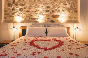 ein Bett mit einem Herz aus roten Blumen in der Unterkunft La Source d'Arbère in Divonne-les-Bains