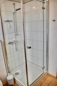 La salle de bains est pourvue d'une douche avec une porte en verre. dans l'établissement "Elter-Emskotten", à Rheine
