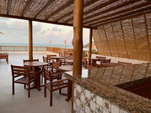 a restaurant with tables and chairs on the beach at Swell Praia Hotel in Natal