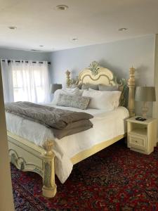 Un dormitorio con una cama grande con sábanas y almohadas blancas. en Baker's Hill Inn, en Bluefield