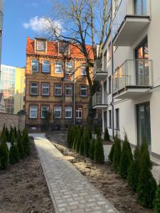 a walkway in front of a building with christmas trees at Apartamenty Garbary 32 z klimatyzacja - air-conditioning in Poznań