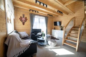 a living room with a couch and a staircase at Domek u Kozika in Krościenko