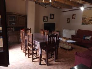 a dining room with a table and chairs and a couch at Casa Rural Marina in Curiel de Duero