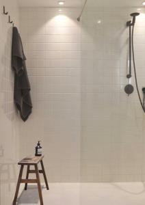 a shower in a bathroom with a wooden stool at Plaisance Appartements & Suites - Bouguenais Apt in Bouguenais