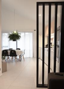 Plaisance Appartements & Suites - Bouguenais Apt في بوغينايس: مطبخ وغرفة طعام مع طاولة وكراسي